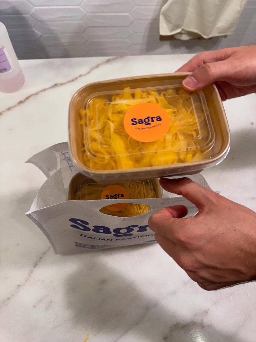 Fresh pasta being packed into a Sagra delivery bag at the restaurant.